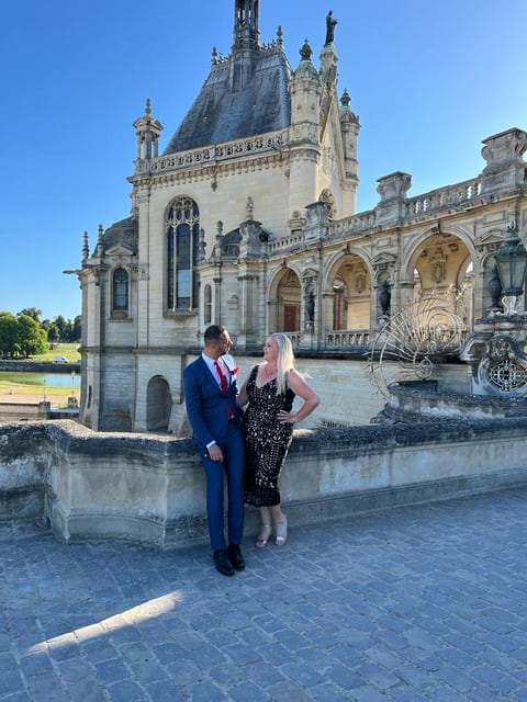 Two guests in evening dress in front of the Château de Chantilly.